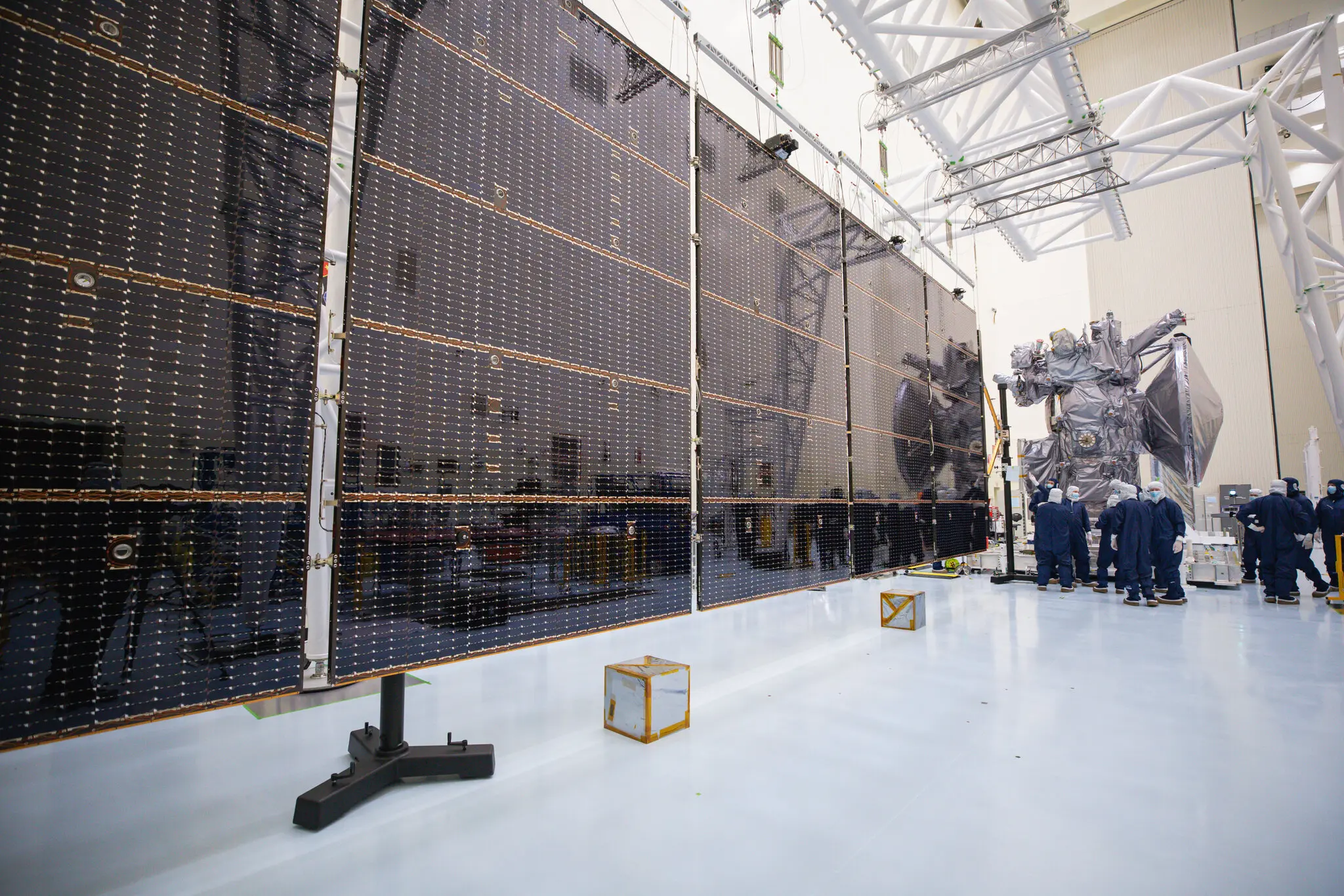 Прикріплення п’ятипанельних сонячних батарей Europa Clipper до космічного корабля всередині центру обслуговування небезпечних корисних навантажень у космічному центрі Кеннеді у Флориді в серпні.